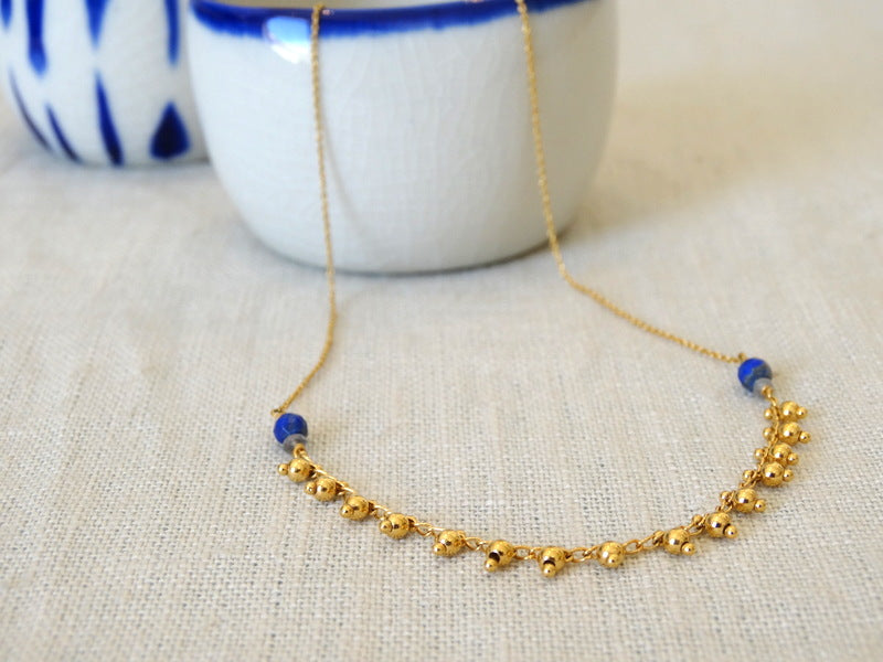 Collier avec chaîne maille forçat et chaîne pampille en laiton doré à l'or fin 24 carats et pierres fines : perles facettées en lapis-lazuli et en labradorite.